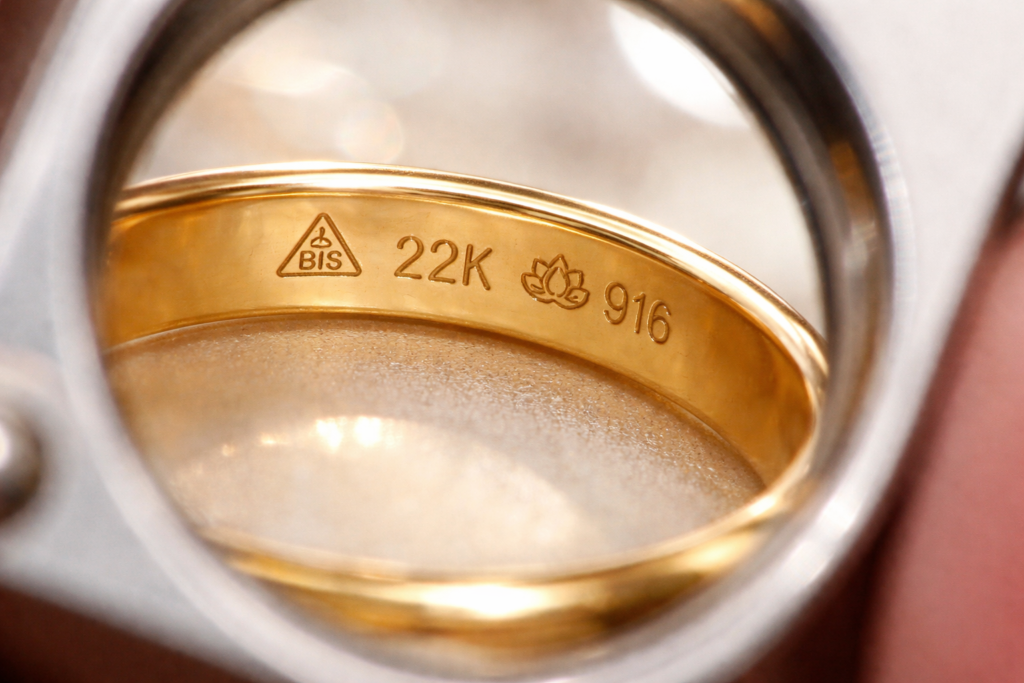 BIS Hallmark on a 22K 916 gold ring viewed through a jeweller's loupe at Charvi Jewels, showcasing authentic BIS Hallmark certification for gold jewellery.